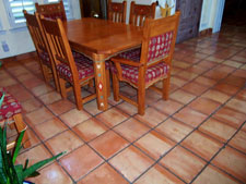 Why Are There Color Variations in Saltillo Tile? Saltillo tile usually varies in colour and shape, however the majority range from in varying hues of reds, oranges and yellows. These beautiful floor tiles are shaped by pressing quarried clay with a wooden frame (super), or could be carving out the desired shape (regular). Depending on the raw tile's placement among other tiles at the time of firing, its colour ranges from yellow to a rich orange. Since each piece of standard Saltillo tile is actually made individually by hand with no modern machinery involved, most pieces will have that individual character. The tile is primitive. There are irregularities. You will find small chips, cracks, and bumps. These imperfections merely add character and rustic quality to the floor. If you are lucky, you might even find a few animal footprints in your tile! With regard to color, lets talk about process a little since this accounts for the major changes you may see from one firing to the next. The tiles are stacked in the caves (kilns) on end which may slightly overlapp so they don't fall over. Then, before firing, the opening to the kiln is sealed with clay to prevent heat from escaping. The fire is started at the bottom of the cave and fuel is added to increase the heat until the proper temperature is reached. As you know, fire will not burn without oxygen, and at sometime during the firing process all of the available oxygen in the atmosphere in the cave is used up. At that point the flame then seeks the next available source of oxygen (which it finds in the form of iron oxide in the clay tile) and burns it, flashing the exposed surfaces of the tile. The light buff color in the tile is the area that was flashed; the peach color in the tile is the area, which is shielded from the flame by other tiles. You may hear many different stories about different types of fuel used in the firing of Saltillo tile. The original source of heat used for firing Saltillo tile was burning rubber tires. Most of the time, wood is now used to start the process. In the past few years, a variety of fuels have also been used, such as propane, diesel, crude petroleum, etc. The type of fuel used for firing does not directly affect the color of the tile. Heat is heat, much like a gas or electric stove. The color of the tiles may vary somewhat due to: Different ways the tile is stacked in the kiln. The way in which the flame/heat is controlled inside the kiln. Depending on if a color additive is added to the clay during the manufacturing process Whether a slight green hue is apparent from the firing process. Regardless of your choice of Mexican tile, be it Saltillo, Mission, Talavera or other varieties, you can't beat these tiling options for creating a traditional, southwestern atmosphere in any room of your house. Our job is to provide a professional installation and then keep them beautiful. Call us today for an estimate on installing, cleaning or restoring the Mexican Tile in your home or business. Keith Clay Floors is happy to assist you with any questions you may still have about Saltillo tile in general. Call us today, you will be so glad you did. World Class Craftsmanship. Reasonable Prices. Call Today: 972-463-6604